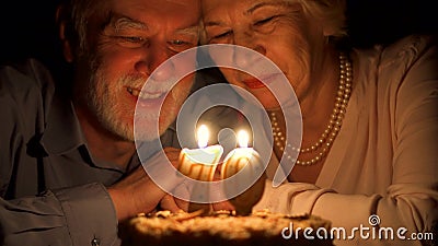Thuis houdend van hogere paar het vieren verjaardag met cake in de avond Uit het blazen van Kaarsen stock video Thuis houdend van hogere paar het vieren verjaardag met cake in de avond Uit het blazen van Kaarsen stock video