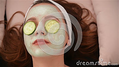 Thuisruimte drie vrouwen houden stukjes komkommer vast op hun gezichten die op het bed liggen schoonheidssalon concept, gezondhei stock video Thuisruimte drie vrouwen houden stukjes komkommer vast op hun gezichten die op het bed liggen schoonheidssalon concept, gezondhei stock video