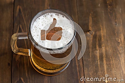 Thumb symbol on foam in glass on black wooden table. Top view Stock Photo