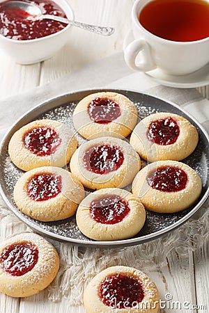 Thumbprint a buttery and crumbly vanilla cookie dough filled with delicious and tart raspberry jam closeup on the plate served Stock Photo
