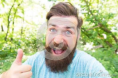 Thumbs up for bearded and beardy. Bearded man giving thumbs up hand gesture on natural landscape. Bearded hipster Stock Photo