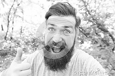 Thumbs up for bearded and beardy. Bearded man giving thumbs up hand gesture on natural landscape. Bearded hipster Stock Photo