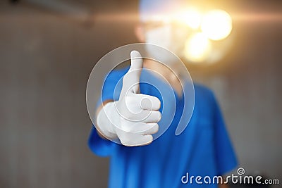 Thumbs up. Doctor in mask and blue costume approves Stock Photo