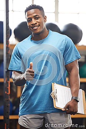 Thumbs up, portrait and fitness man in gym, clipboard and checklist for workout results, progress and like, yes or okay Stock Photo