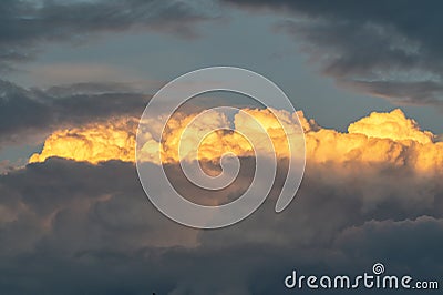 Lit yellow sunlight thundercloud at sunset Stock Photo