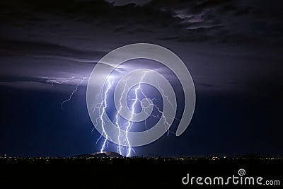 Thunderstorm with lightning bolt strikes and storm clouds over a city Stock Photo