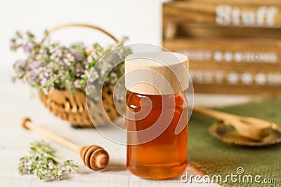Thyme honey in a jar on a white wooden background Stock Photo