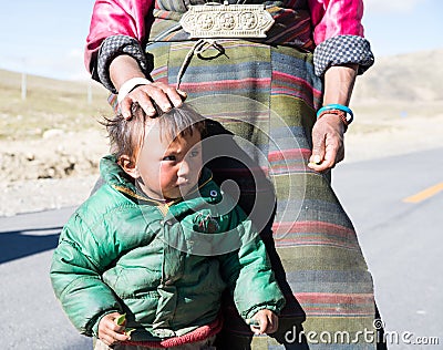 A Tibetan farmer with her kid Editorial Stock Photo