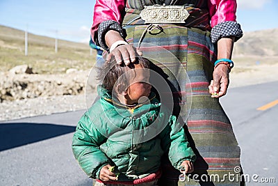 A Tibetan farmer with her kid Editorial Stock Photo