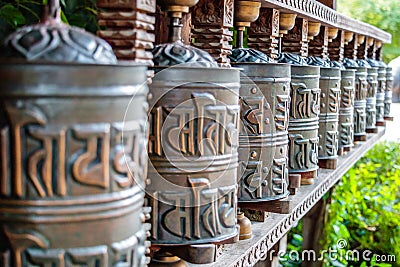 Tibetan prayer wheels, cylindrical rolls on a spindle made from metal and wood, selective focus Stock Photo