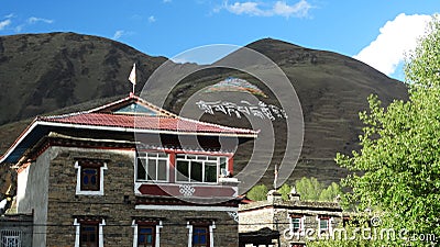 Tibetan religious painting and writing on a mountainside Editorial Stock Photo