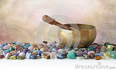 Tibetan Singing Bowl surrounded by tumbled healing stones Stock Photo