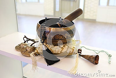 Tibetan Singing Bowl and Tingsha for Yoga, Relaxation, and Meditation on Display Shelf Stock Photo