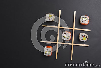 Tic tac toe game with sushi on dark black background, creative concept sushi rolls. Banner, playing tic tac toe game Stock Photo