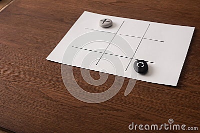 Tic tac toe game on white paper with pebbles marked with naught and cross Stock Photo