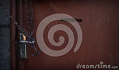 Tie a chain to an old iron gate opener in front of the house. Stock Photo
