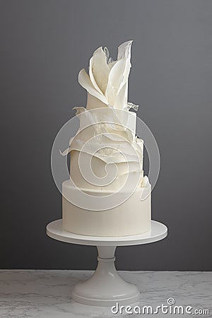 4 Tier Trendy Wedding Cake Decorated With Ruffles And Pulled Sugar Stock Photo