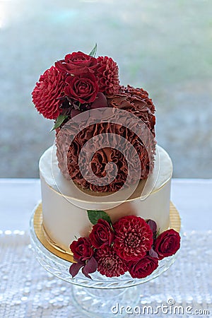 2 tier wedding cake decorated with gold and red rosette ruffles Stock Photo