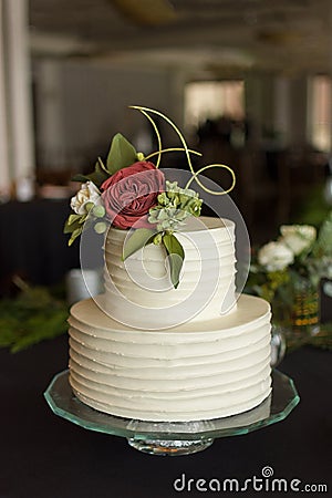 2 tier wedding cake decorated with pleated buttercream and edible rose floral arrangement Stock Photo
