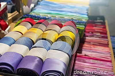 Ties of red shade and twisted into a spiral colorful tones with strict design pattern are folded in row in the window of Stock Photo