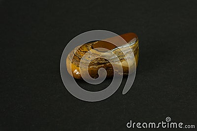 Tiger's eye stone from Republic of South Africa RSA. Natural mineral stone on black background. Mineralogy, geology Stock Photo