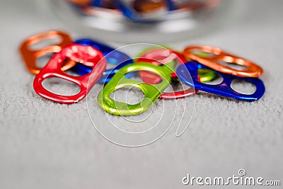 Tight close up view of a number of multi colored can pull tabs lying loose Stock Photo