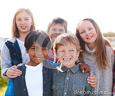 We are a tight group of friends. Portrait of a group of cheerful elementary school kids standing next to each other Stock Photo