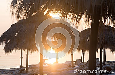 Tiki hut umbrellas, thatch. Sunrise view on beach in Tunisia. Sousse Stock Photo