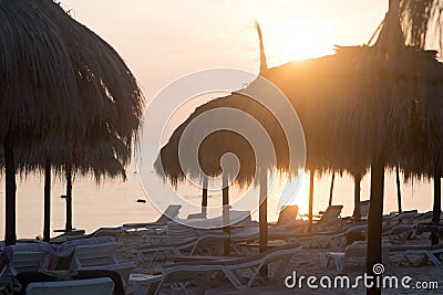 Tiki hut umbrellas, thatch. Sunrise view on beach in Tunisia. Sousse Stock Photo