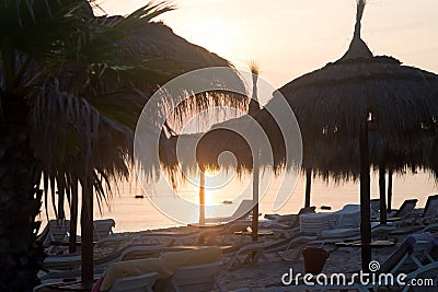 Tiki hut umbrellas, thatch. Sunrise view on beach in Tunisia. Sousse Stock Photo