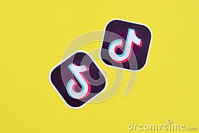 Tiktok paper logo on yellow background. TikTok is a popular video-sharing social networking service owned by ByteDance Editorial Stock Photo