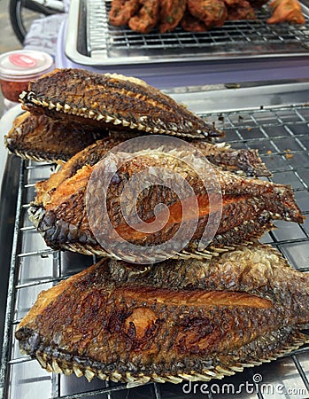 Tilapia fried fish on steel grille. It is a side dish. Stock Photo