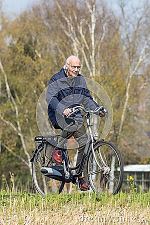 Cycling male senior enjoys the spring weather, Brabant, Netherlands Editorial Stock Photo