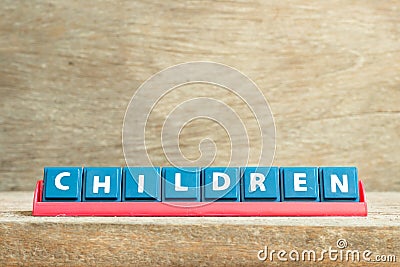 Tile letter on rack in word children on wood background Stock Photo