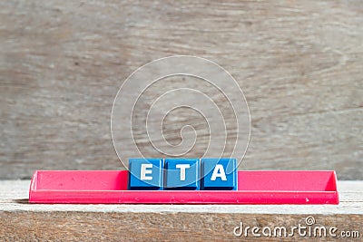 Tile letter on rack in word ETA abbreviation of estimated time of arrival on wood background Stock Photo