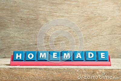 Tile letter on rack in word homemade on wood background Stock Photo