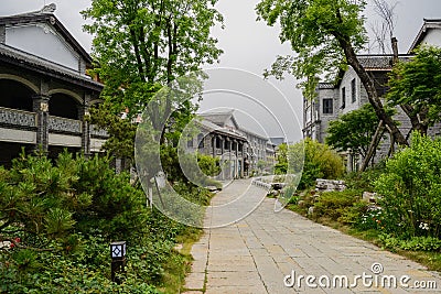 Tile-roofed buildings along flagstone street in cloudy spring Editorial Stock Photo