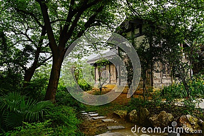 Tile-roofed timberwork building behind trees in cloudy spring af Stock Photo