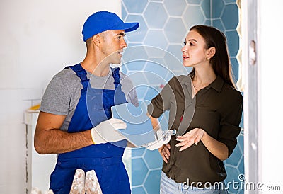 Tile setter discussing works in bathroom with woman Stock Photo