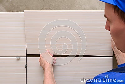 Tiler lays the tiles on the wall Stock Photo