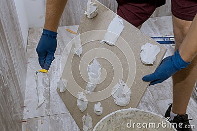 Tiler and plaster repair work laying tile, trowel in a man hand Stock Photo