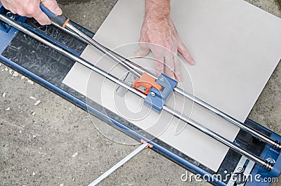 Tiler using a tile cutter Stock Photo