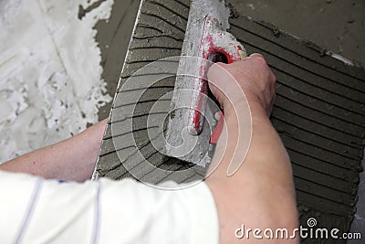 Tiler at work bonding of floor tile adhesive Stock Photo