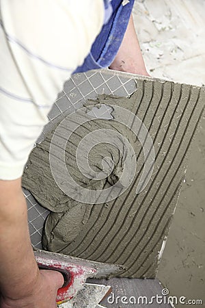 Tiler at work bonding of floor tile adhesive Stock Photo