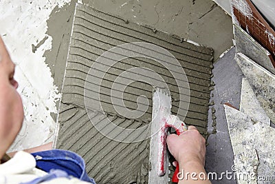 Tiler at work bonding of floor tile adhesive Stock Photo