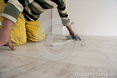 Tilers filling the space between ceramic wood effect tiles Stock Photo