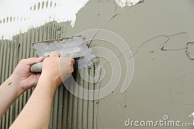 Tilers hands are putting an adhesive. Stock Photo