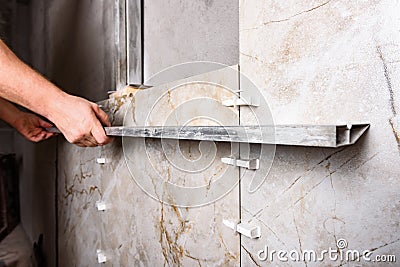 Tilers installing large format tiles on wall. Stock Photo