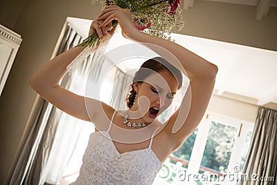 Tilt image of angry bride throwing bouquet at home Stock Photo