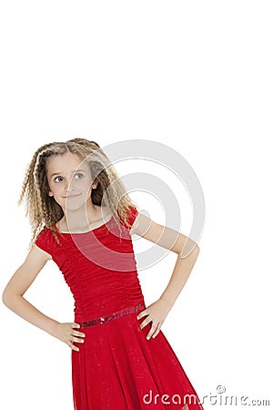 Tilt image of girl wearing red frock looking sideways with hands on hips over white background Stock Photo